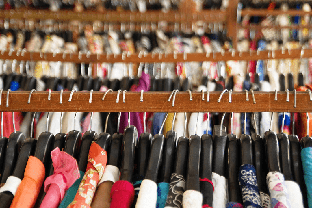 Diversas araras com diversas peças de roupas em cabides a perder de vista